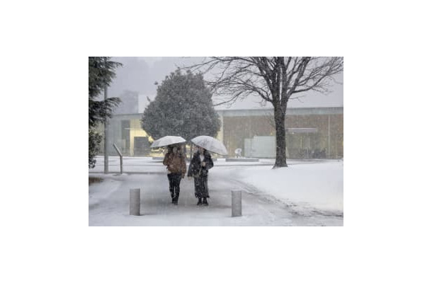 雪が降る金沢市内を歩く人たち＝13日午後4時43分