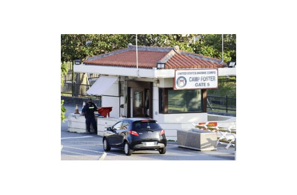 9日、沖縄県北谷町の米軍キャンプ・フォスターのゲート前で車両のチェックをする関係者