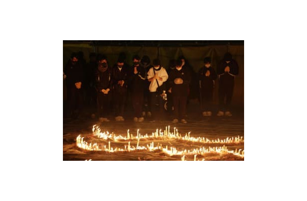 兵庫県伊丹市の昆陽池公園で行われた阪神大震災の追悼集会で、手を合わせる人たち＝16日午後5時46分