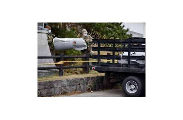 米軍三沢基地のF16戦闘機が投棄した燃料タンクの一部を落下現場から回収する米軍関係者＝2021年12月、青森県深浦町