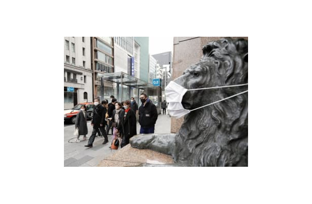 東京・銀座をマスク姿で歩く人たち。百貨店前のライオン像もマスクを着けられていた＝30日午後
