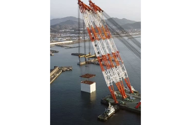 大型クレーン船でつり上げられる巨大ケーソン＝2日午前、高知港（四国地方整備局高知港湾・空港整備事務所提供）