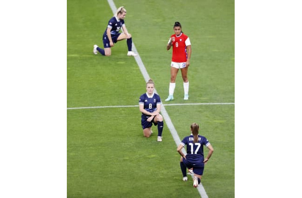 東京五輪サッカー女子の試合前のピッチで、人種差別に抗議し片膝をつく英国代表の選手ら＝2021年7月、札幌ドーム