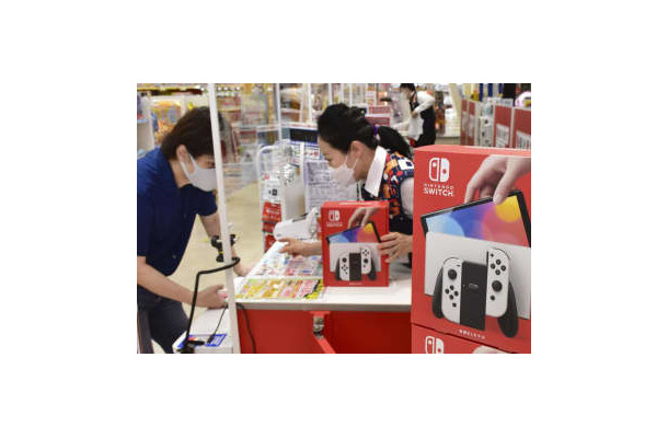 大阪市内の家電量販店で「ニンテンドースイッチ」を購入する男性（左）＝2021年10月