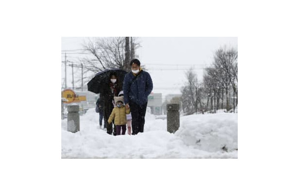 大雪が降り続く中、滋賀県米原市を歩く人たち＝6日午後