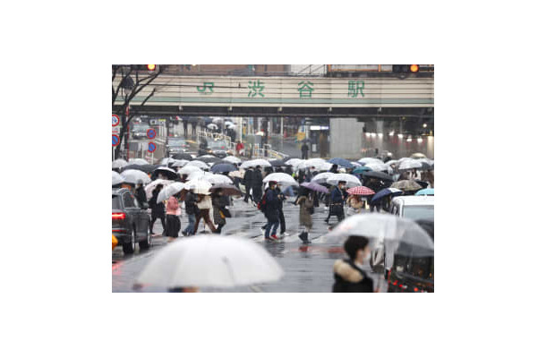 雪が降る中、東京・渋谷を歩く人たち＝10日午後