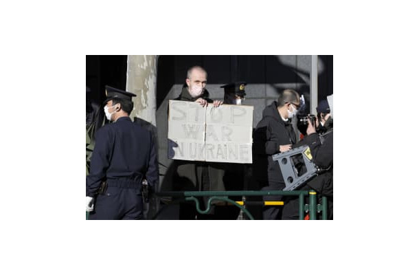 ロシア大使館前でボードを掲げる男性＝24日午後、東京都港区