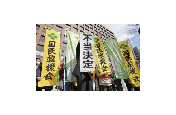 再審開始を認めない決定に、名古屋高裁前で「不当決定」と書かれた紙を掲げる弁護士＝3日午前