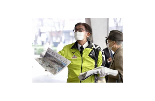 JR有楽町駅前で、特別号外を配布する岩手日報社の東根千万億社長＝11日午前