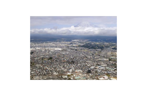 富士山（奥）と静岡県富士宮市の市街地。「富士山火山防災対策協議会」は噴火に備えた避難計画を部分改定する中間報告書を公表した＝30日午後（共同通信社ヘリから）