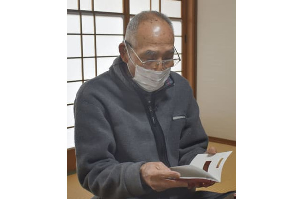 被爆者健康手帳を見る斉藤修吾さん＝1日午後、広島市