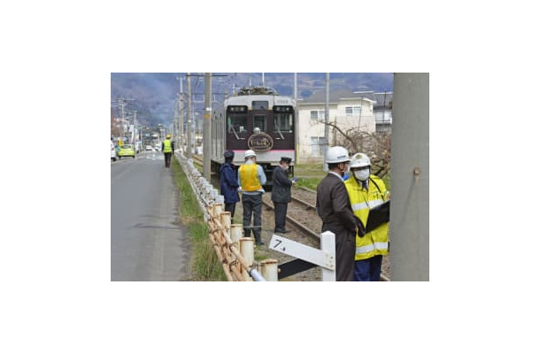 電車と軽乗用車が衝突した現場付近を調べる捜査員ら＝5日午前11時24分、福島市飯坂町