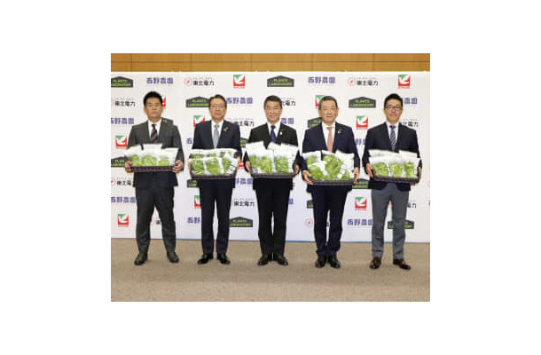出荷するレタスを手に記念撮影する西野農園の西野拓社長（右端）ら＝6日午前、仙台市