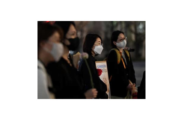 JR東京駅前で行われた「フラワーデモ」。参加者は花やプラカードを手に性暴力撲滅を訴える言葉に耳を傾けた＝11日夜