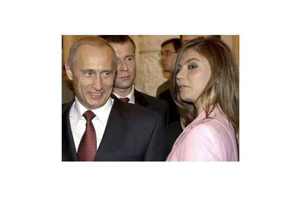 アリーナ・カバエワさん（右）の隣で笑顔を見せるロシアのプーチン大統領＝2004年11月、モスクワのクレムリン（ロイター＝共同）