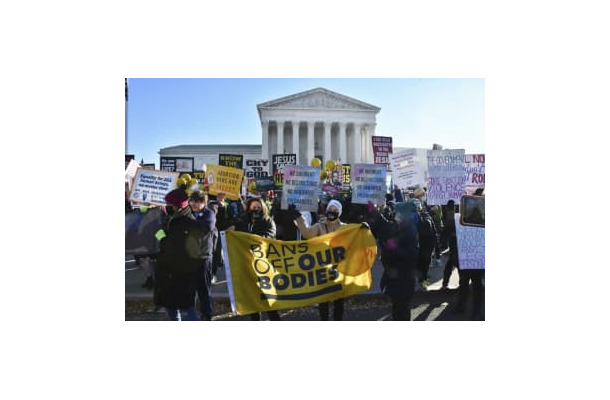 昨年12月、米連邦最高裁前でプラカードや横断幕を掲げる人工中絶擁護、反対両派の人たち＝米ワシントン（共同）