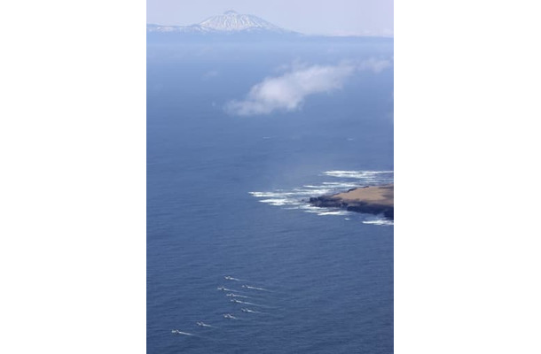 4月30日、北海道・知床半島沖で捜索する漁船団（左下）。奥は国後島（共同通信社ヘリから）