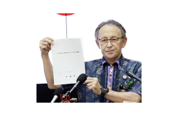 記者会見で「平和で豊かな沖縄の実現に向けた新たな建議書」を手にする沖縄県の玉城デニー知事＝7日午後、県庁