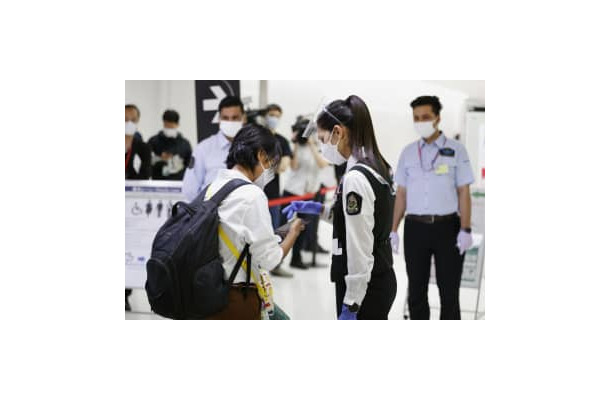 成田空港に到着し、空港職員（手前右）に携帯電話の専用アプリ画面を見せる人＝1日
