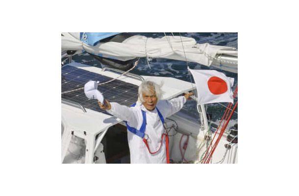 ヨットで単独無寄港の太平洋横断に成功し、帽子を振る堀江謙一さん＝4日午後2時52分、大阪湾（共同通信社ヘリから）