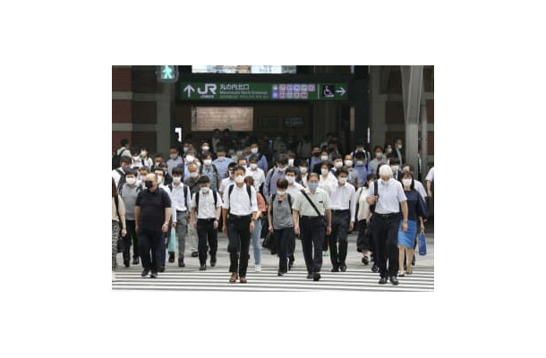 東京駅前をマスク姿で通勤する人たち