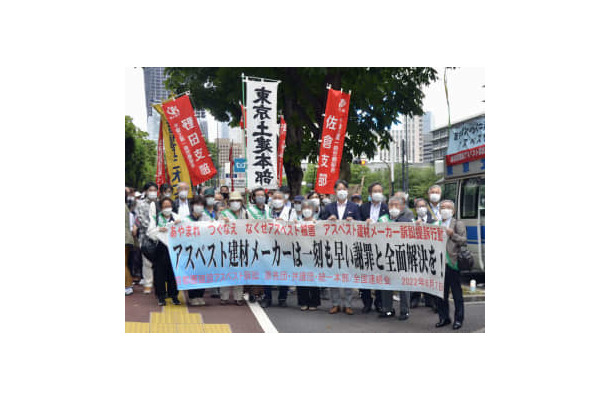 建材メーカーに損害賠償を求め、東京地裁に提訴に向かう原告と弁護団＝7日午前、東京・霞が関