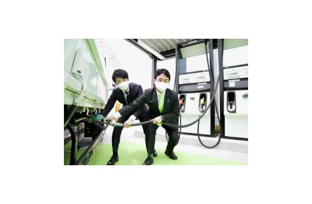 給油所で次世代バイオディーゼル燃料をPRするユーグレナの出雲充社長（右）ら＝10日午前、名古屋市