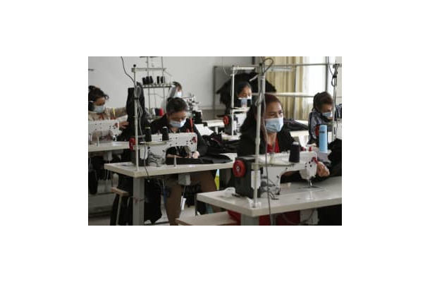 縫製工場で働くウイグル族の作業員ら＝2021年5月、中国新疆ウイグル自治区カシュガル（共同）
