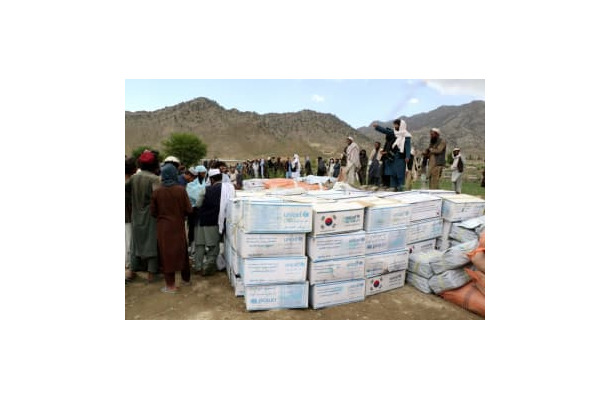 支援物資を受け取るため、集まる被災者ら＝23日、アフガニスタン東部（ロイター＝共同）