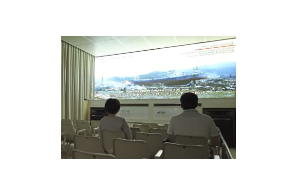閉館の日を迎えた津波体験館で映像を見る来館者＝26日午後、宮城県気仙沼市