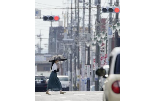 梅雨明けしたとみられる栃木県佐野市で、猛暑の中を歩く女性＝27日午後