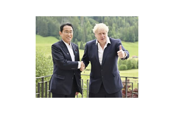 会談で握手する岸田首相（左）とジョンソン英首相＝28日、ドイツ南部エルマウ（代表撮影・共同）