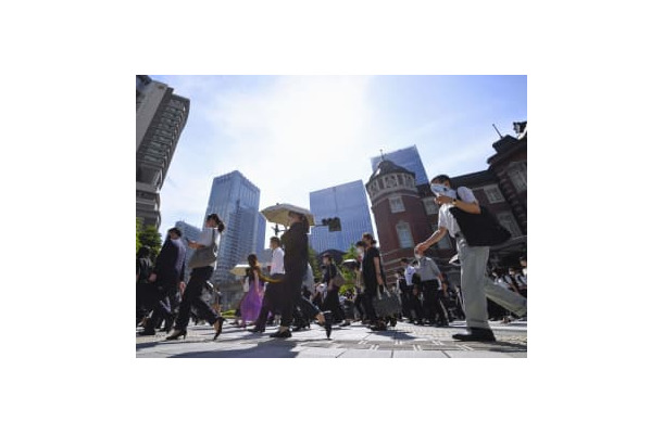 強い日差しの中、日傘を差して歩く人たち＝30日午前、JR東京駅前