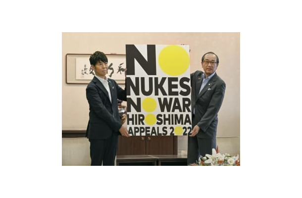 広島市役所で、松井一実市長（右）に「ヒロシマ・アピールズ」のポスターを贈呈する佐藤可士和さん＝15日午前
