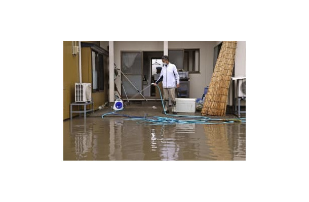 大雨の影響で浸水した自宅の掃除をする男性。家屋は床上1メートルまで水に漬かり、冷蔵庫やテレビなどの家電製品が壊れたという。「この7年で3回目の被害。堤防をしっかりと整備してほしい」と訴えた＝17日午前、宮城県大崎市