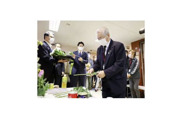 船内の献花台に花を供える色丹島出身の得能宏さん＝23日午前、北海道根室半島沖の洋上