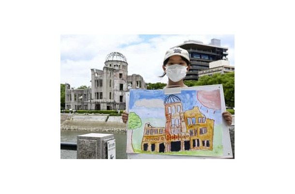 原爆ドームの絵を描いた栗原莉奈さん＝23日午後、広島市の平和記念公園