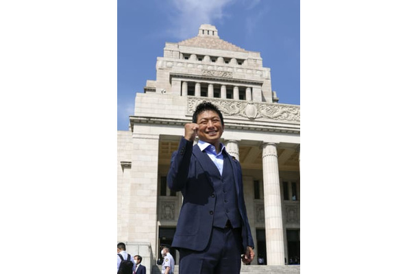 国会に初登院しポーズをとる参政党の神谷宗幣参院議員＝3日午前8時55分