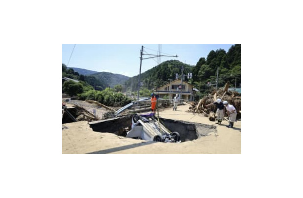 道路の陥没部分から引き上げられる車＝8日、福井県南越前町
