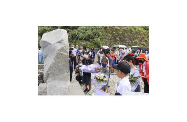 学童疎開船「対馬丸」をテーマにした学習事業で、慰霊碑に花を供える子どもたち＝20日午前、鹿児島県宇検村
