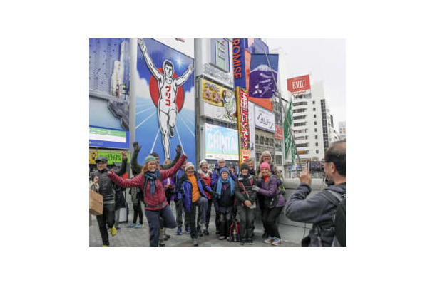 大阪・ミナミの名所、グリコの看板前でポーズを取る訪日観光客ら＝2019年4月