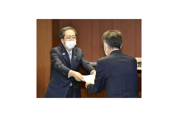 日野自動車の小木曽聡社長（右）に是正命令書を手渡す斉藤国交相＝9日午後、国交省