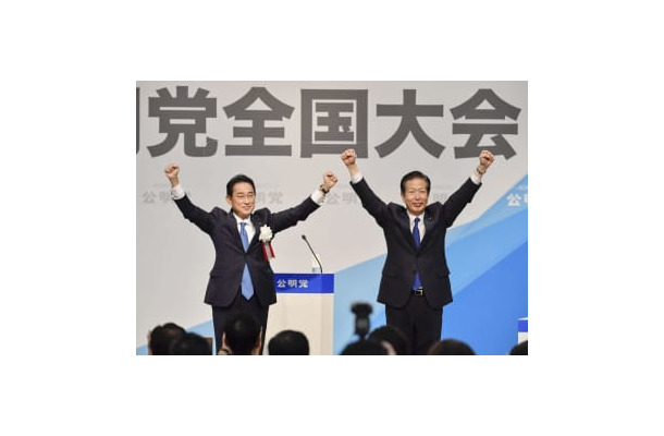 公明党の党大会で来賓あいさつを終え、山口代表（右）と両手を上げる岸田首相＝25日午後、東京都内のホテル