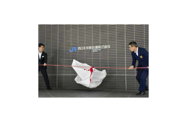 JR西日本中国統括本部の看板を披露する蔵原潮本部長（右）ら＝3日午前、広島市