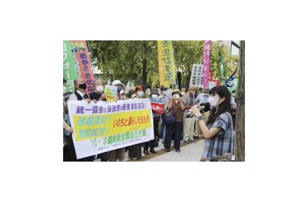 国会議事堂前で横断幕やプラカードを持ち、抗議活動する参加者＝3日午後、東京・永田町