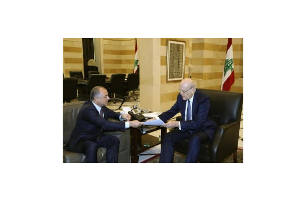 11日、イスラエルとの海洋境界画定の最終案を交渉担当の高官から受け取るレバノンのミカティ首相（右）＝ベイルート（AP＝共同）