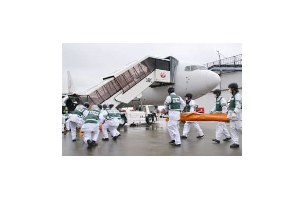 航空機事故を想定し、救助活動の訓練をする参加者ら＝13日午後、成田空港