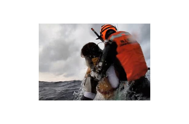 沖縄・波照間島沖で海上保安庁に救助される女性（左）＝14日午前（第11管区海上保安本部提供）