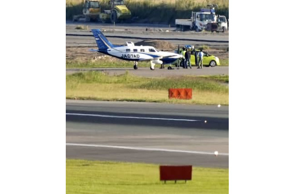 誘導路上でパンクした小型航空機。手前は福岡空港の滑走路＝20日午後4時37分