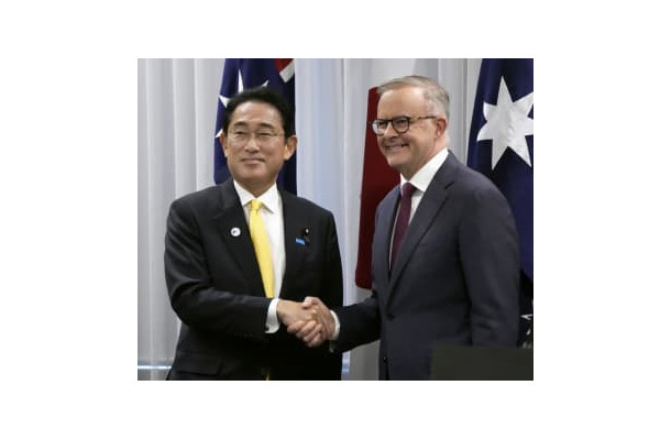 共同記者発表を終え、オーストラリアのアルバニージー首相（右）と握手する岸田首相＝22日、パース（共同）